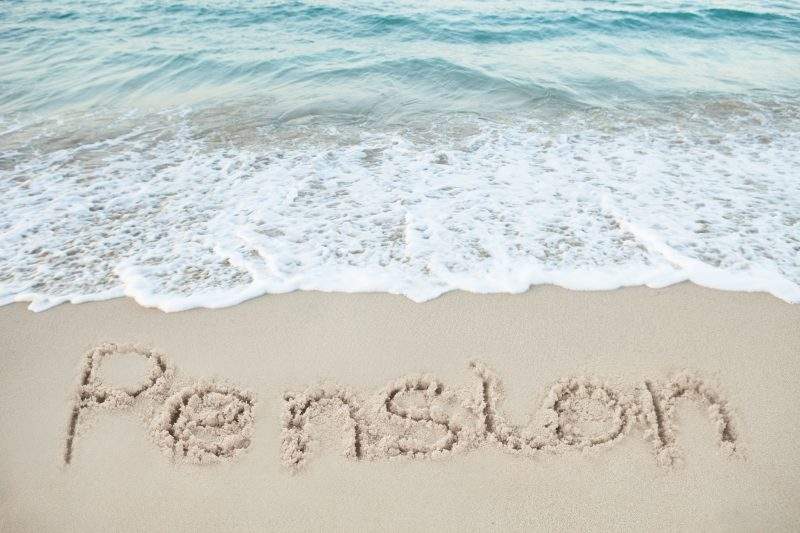 This is a lovely holiday scene there is the beautiful light blue sea in the top of the image then the white of the sea foam. In the foreground someone has written the word pension in the sand