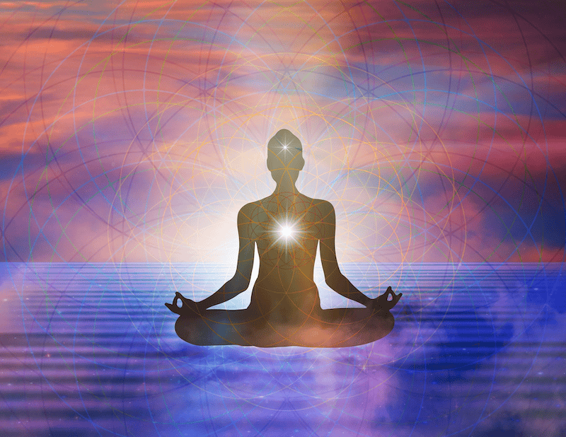 Silhouette of a person sat in mediation with a bright light coming from their heart centre and third eye. It look slike they are sat on ripples of violet water and a sunset behind. Representing the importance to listen to your inner wisdom