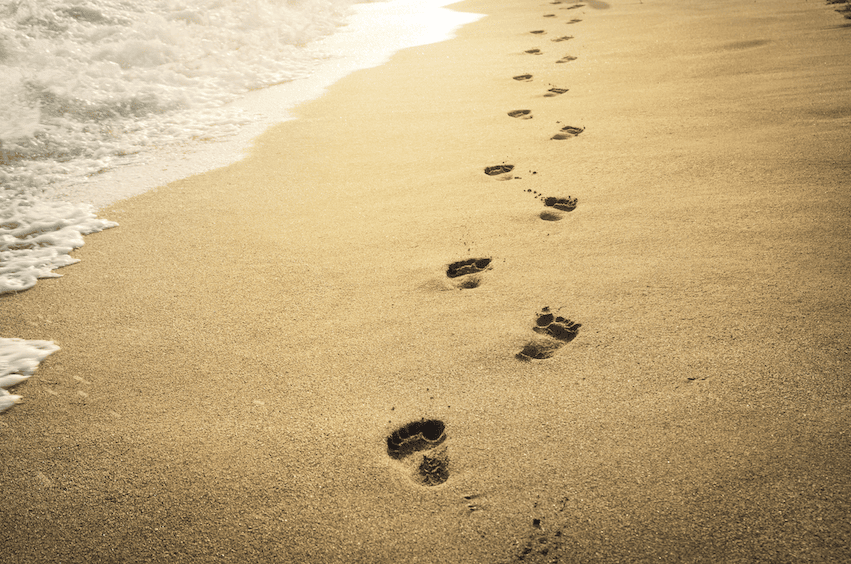 Footsteps on a beach going into the distance